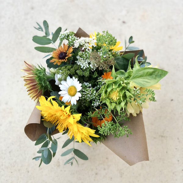 Greensboro, NC | Our locally-grown, pesticide-free summer flowers are finally here! Everything is either blooming or ready to pop this month – sunflowers in shades of plum, cream yellow, dark red, and radiant gold, lisianthus that are soft like roses, the always-a-hit zinnias, the ever cheerful daisies, and a range of herb and edible flowers like calendulas, oregano, and basil.   We can't be more excited to share with you that broad range of summer flowers, and labor of our garden love! 
